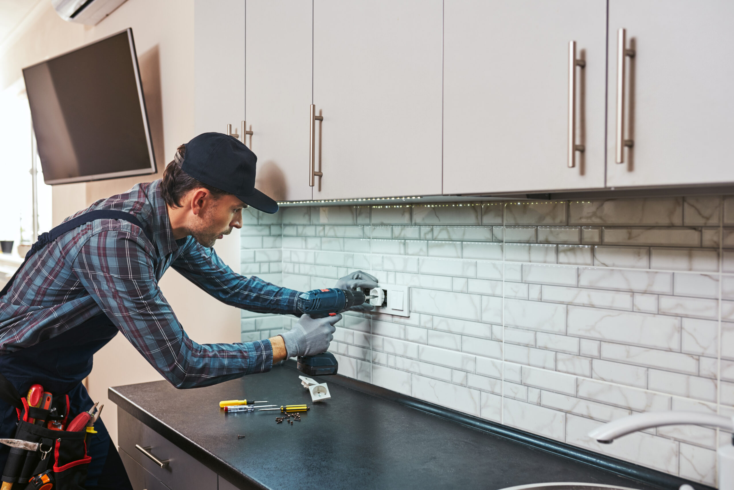 Elektricien bezig met stopcontacten voor de keuken elektra renovatie